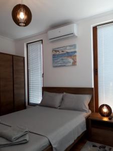 a bedroom with a bed and two windows at Lighthouse 3 bedrooms villa F36 in Balchik