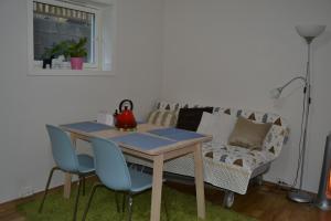 a table and chairs in a living room with a couch at Totally independent apartment near NTNU,Lerkendal and Center in Trondheim