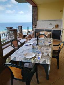 a table on a balcony with a view of the ocean at Dimora La Conchiglia in Buggerru