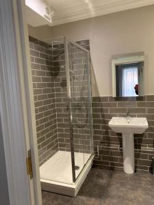 a bathroom with a shower and a sink at Denvir's Coaching Inn in Downpatrick