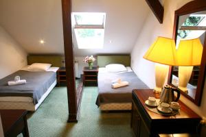 Cette chambre comprend deux lits, une lampe et un miroir. dans l'établissement Miodosytnia Aparthotel, à Cracovie