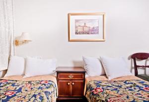 クラクフにあるミオドシティニャ アパートホテルのベッド2台とテーブル(写真付)が備わる客室です。
