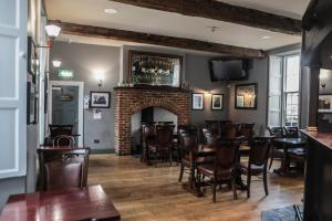 a restaurant with a fireplace and tables and chairs at Denvir's of Downpatrick in Downpatrick