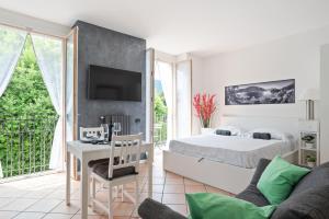 1 dormitorio con 1 cama, escritorio y TV en Lake Como Studio with Balcony and Private Parking, en Ossuccio