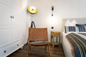 a bedroom with a bed and a chair next to a bed at Club Alpenresidenz Gastein in Bad Gastein