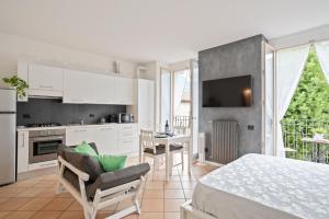 a kitchen and living room with a bed and a table at Lake Como Studio with Balcony and Private Parking in Ossuccio