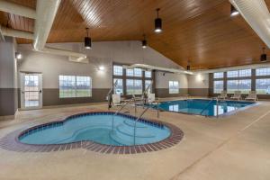 a pool in a building with two swimming pools at AmericInn by Wyndham Fulton Clinton in Fulton