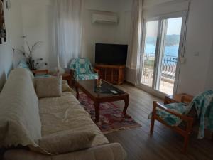 a living room with a couch and chairs and a television at Heybe Apart in Kaş