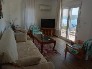 a living room with a couch and chairs and a television at Heybe Apart in Kas