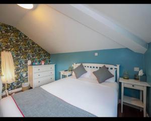 a bedroom with a white bed and blue walls at The Oak Baginton in Coventry