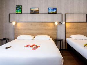 A bed or beds in a room at Ibis Centre Millau