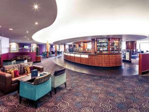 a hotel lobby with a waiting area with couches and chairs at Mercure Manchester Piccadilly Hotel in Manchester