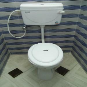 a bathroom with a white toilet in a room at Sukun Guest House in Siliguri