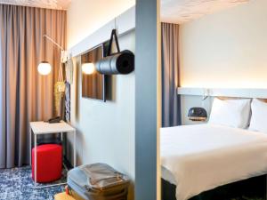 a hotel room with a bed and a camera on the wall at ibis Bucharest Politehnica in Bucharest