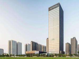 a tall building in a city with tall buildings at Pullman Jiaxing Pinghu Excellence in Jiaxing