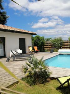 Un patio trasero con piscina y terraza de madera. en Et c'est une autre histoire studio, en Léon