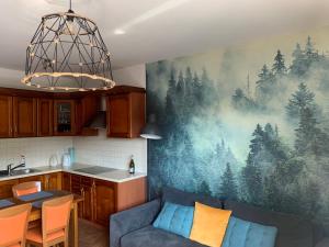 un soggiorno con un dipinto di alberi sul muro di Apartament na Wzgórzu a Wisła
