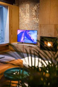 un salon avec une télévision et une cheminée dans l'établissement Studio73, Guesthouse met sauna, à Courtrai