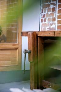 a wooden bench next to a door with a hammer at Studio73, Guesthouse met sauna in Kortrijk