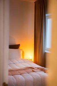 a bed sitting in a bedroom with a window at Studio73, Guesthouse met sauna in Kortrijk