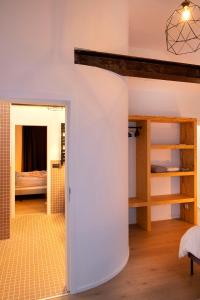 a room with a white wall and a room with a bedroom at Studio73, Guesthouse met sauna in Kortrijk