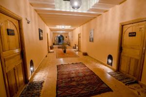 a hallway with a rug in the middle of a building at Hassilabiad Appart Hotel in Merzouga