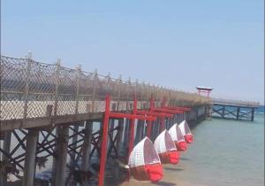 a pier with a row of surfboards on the water at Mohamed Afifi BlueBay Asia - Families - Ground 2 Bed Rooms in Ain Sokhna