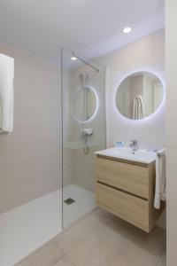 a white bathroom with a sink and a shower at Aparthotel BCL Levante Beach in Benidorm