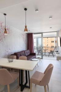 a living room with a couch and a table and chairs at Aparthotel BCL Levante Beach in Benidorm