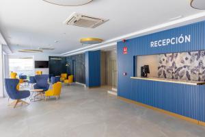 una hall con ufficio e sedie blu e gialle di Aparthotel BCL Levante Beach a Benidorm