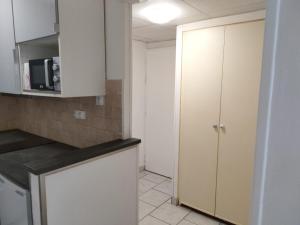 een keuken met witte kasten en een aanrechtblad bij Studio Galy in Metz