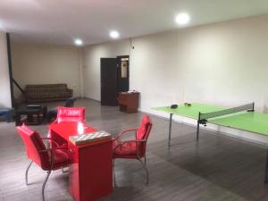 a room with a ping pong table and red chairs and a ping pong at Batumi Hotel in Batumi