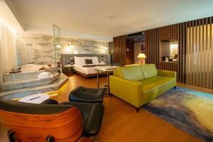 a living room with a bed and a yellow couch at The Craton Hotel Sisli in Istanbul