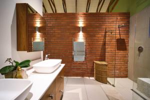 a bathroom with a sink and a brick wall at The Cottage Farm in Stellenbosch +10 photos