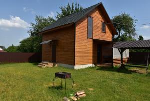 a small house with a grill in the yard at Коттедж Злата in Svityazʼ