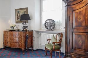 a room with a chair and a dresser and a window at Villa Adolphine in Rottach-Egern