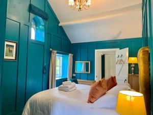 a bedroom with blue walls and a white bed at Octon Cottages Luxury 1 and 2 Bedroom cottages 1 mile from Taunton centre in Taunton
