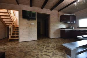 a room with a kitchen and a tv on a wall at Коттедж Злата in Svityazʼ