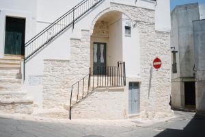 a white building with a door and stairs on it at Casa Sotto l'Arco in Ceglie Messapica