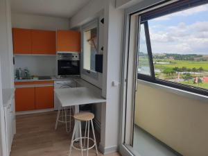una cocina con armarios naranjas y una ventana grande en VUE PANORAMIQUE, en Courseulles-sur-Mer