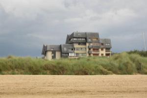 una casa en la cima de una colina con un campo en VUE PANORAMIQUE, en Courseulles-sur-Mer