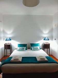 a bedroom with a large bed with blue pillows at First In in Corroios