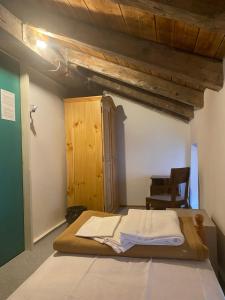 - une chambre avec un lit et un plafond en bois dans l'établissement Casa delle Giuggiole, à Dogna