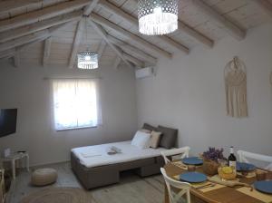 a living room with a couch and a table at Paliokaliva Home in Roussopoúlion