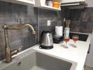 a kitchen counter with a sink and two glasses of wine at Paliokaliva Home in Roussopoúlion +103 photos
