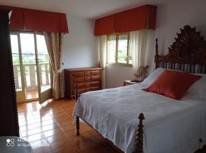 a bedroom with a bed with a red pillow on it at A Casa De Amparo in Sanxenxo