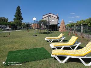 three lounge chairs in a park with a playground at A Casa De Amparo in Sanxenxo