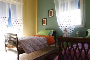 a bedroom with a bed and two windows at Casa di Nonna Signorina in Giarre