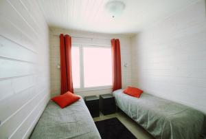 アカスロンポロにあるLapland Happiness Hillakka 2 a8のベッド2台と窓が備わる小さな客室です。
