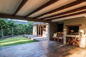 Un patio al aire libre con chimenea y césped. en Home in Cape Town-The Homestead, en Stellenbosch